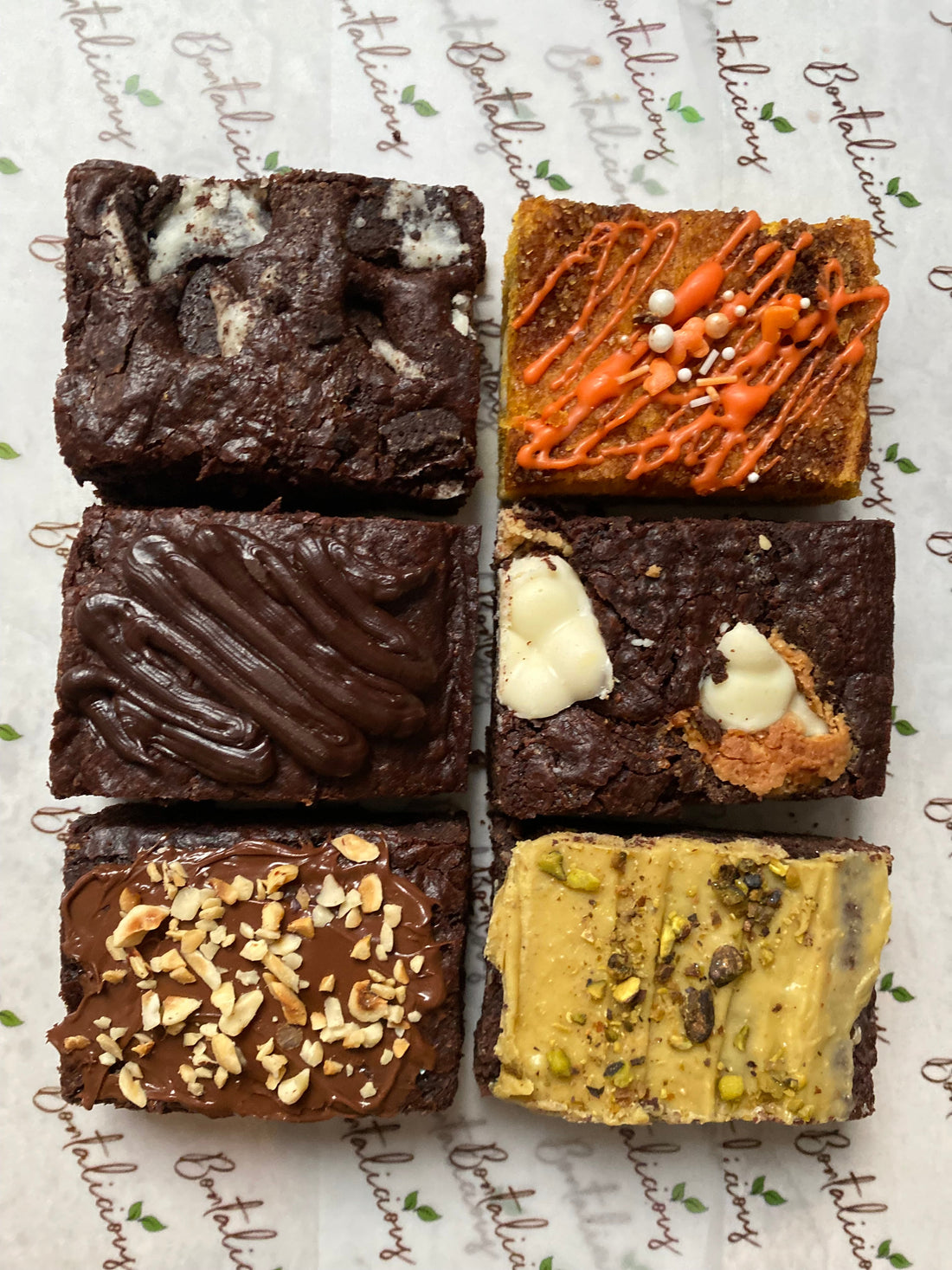 Vegan and gluten-free mixed brownie box with assorted flavours including pistachio, hazelnut, cookies and cream, and pumpkin spice.
