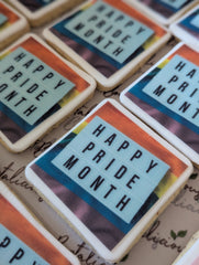 Cookies with 'Happy Pride Month' text on a surface with visible text underneath.